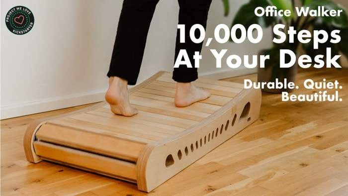 Office Walker campaign image, barefoot walking on the light wood model at a desk