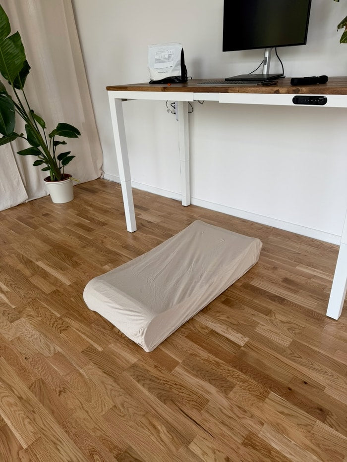 A baby crib fitted sheet stretched over the Office Walker as a dust cover